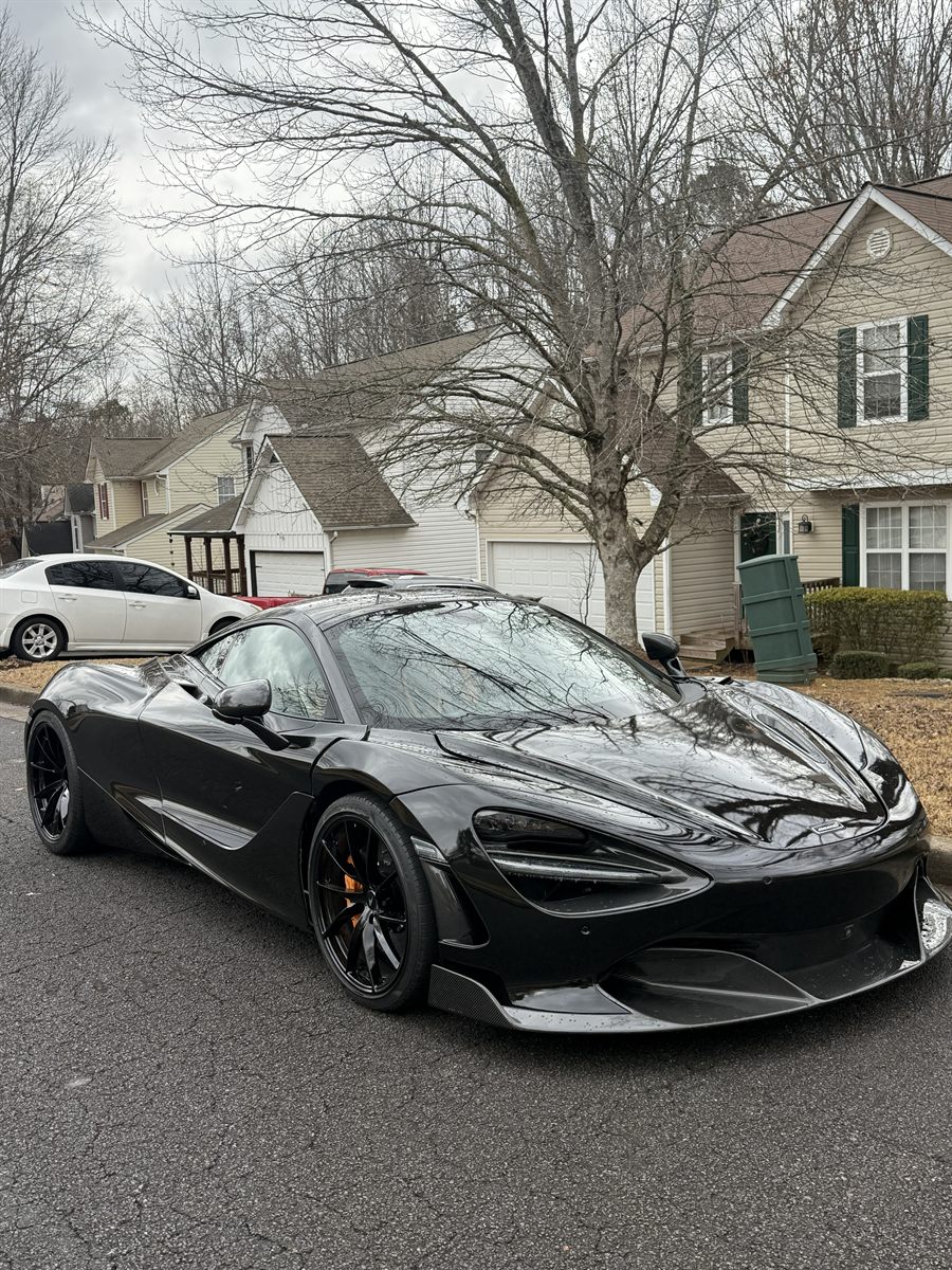 McLaren 720S in gloss black with blacked-out wheels and tinted glass
