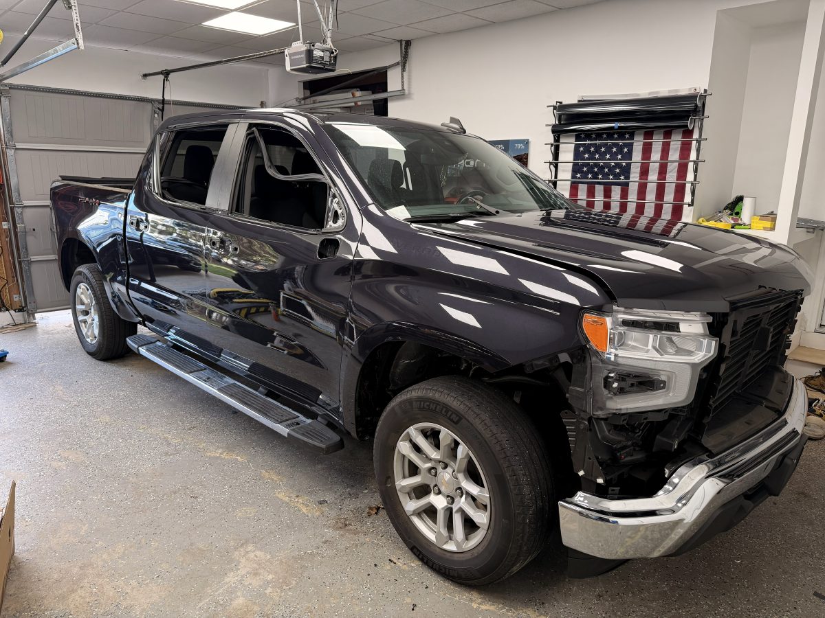 Chevrolet Silverado with freshly tinted glass, front end partially disassembled during the install