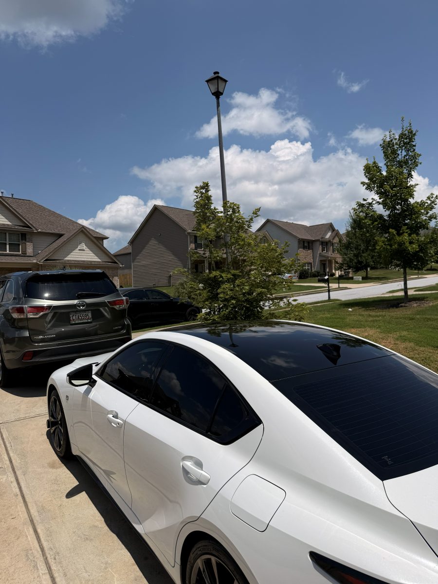 White sedan with a blacked-out roof and tinted glass, parked in a driveway